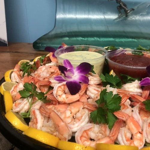 A tray of shrimp and dipping sauces